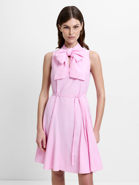 Woman wearing a pink sleeveless mini dress with a large bow neckline