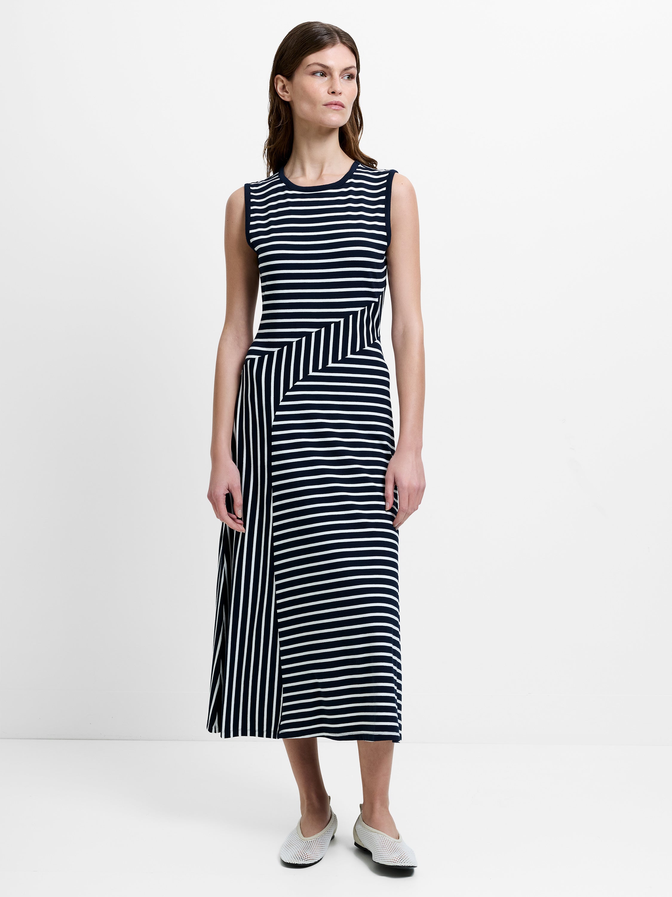 Woman wearing a sleeveless black and white striped midi dress 