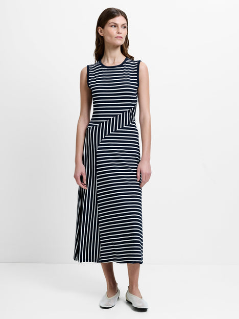 Woman wearing a sleeveless black and white striped midi dress 