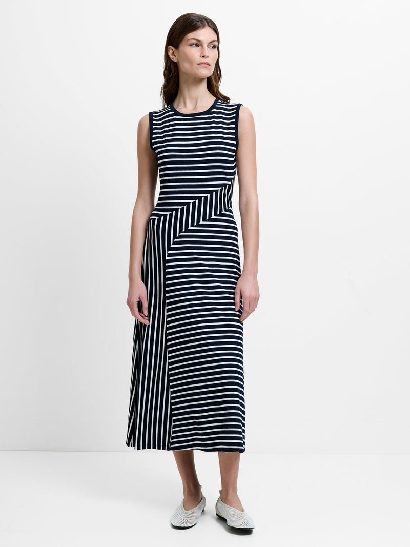 Woman wearing a sleeveless black and white striped midi dress 
