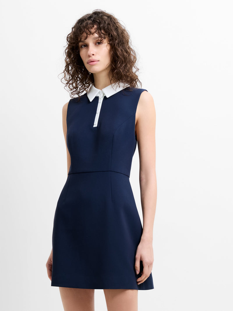 Woman wearing a navy blue mini  dress with a white collar 