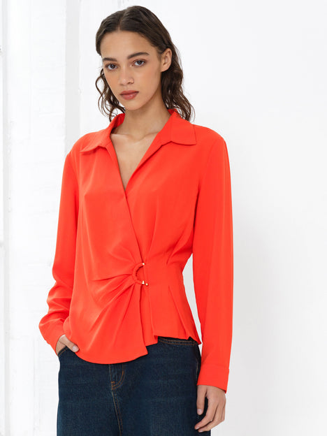 Woman wearing a bright orange long sleeve wrap over shirt