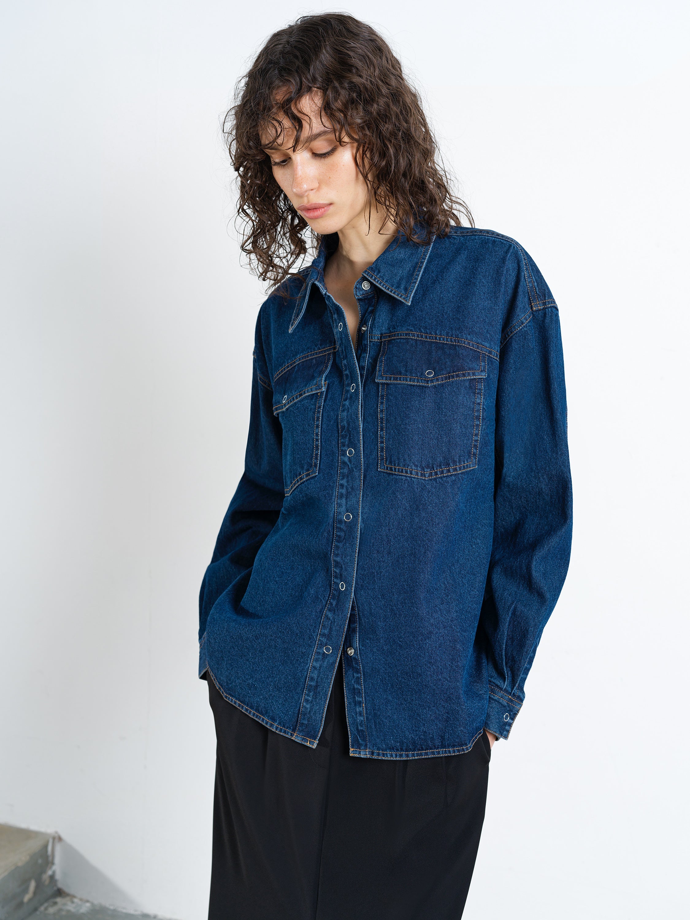 Woman wearing a long sleeve blue denim shirt with two pockets