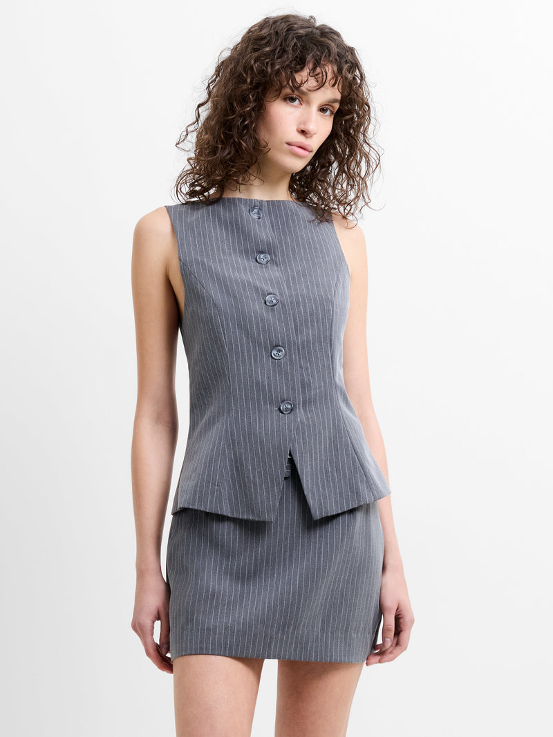 Woman wearing a grey pinstripe waistcoat and mini skirt co-ord 