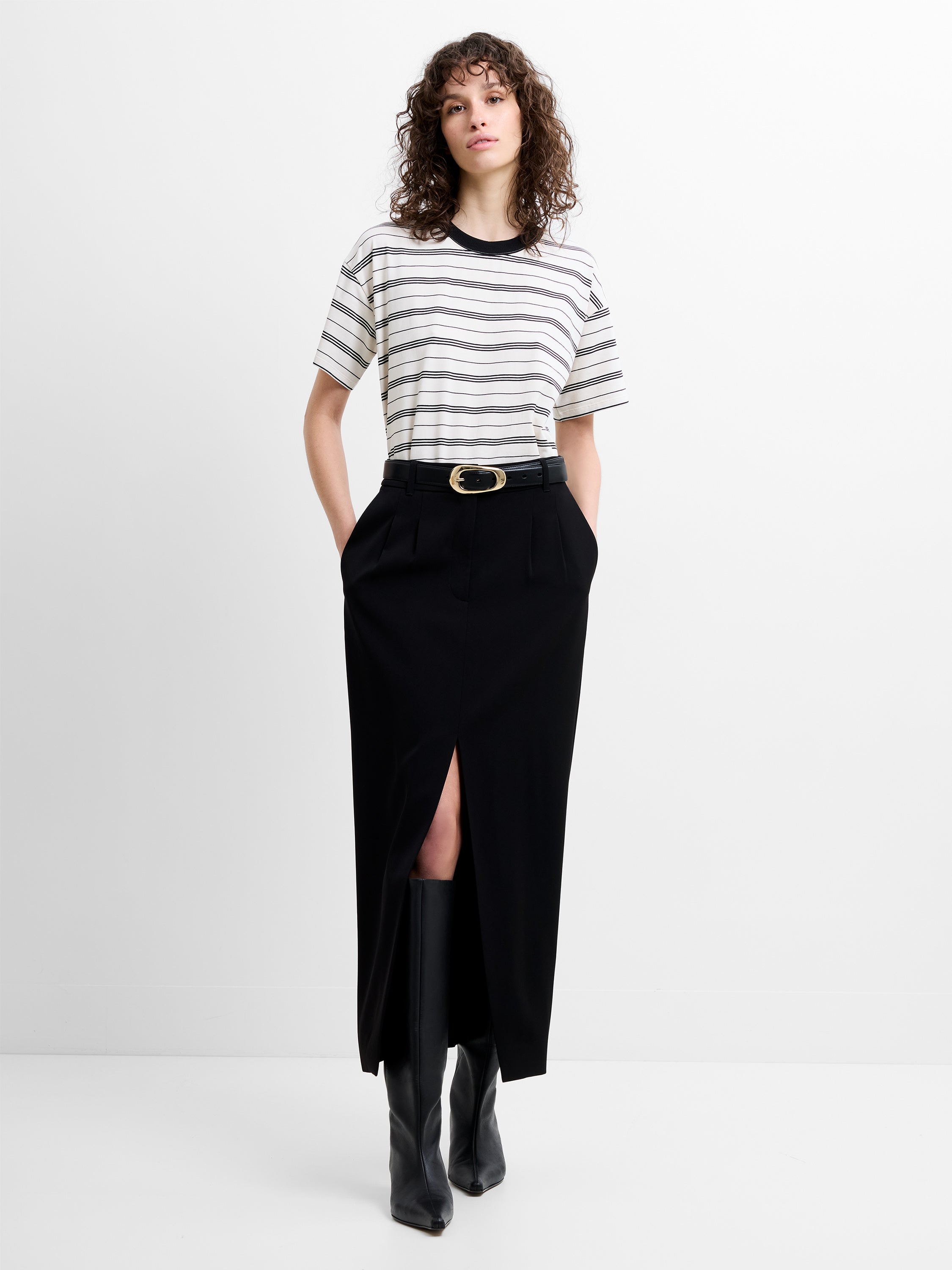 Woman wearing a striped T-shirt and a black front slit midi skirt 