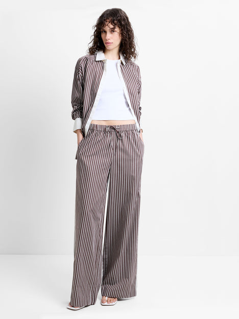 Woman wearing high waisted, wide leg brown and white striped trousers
