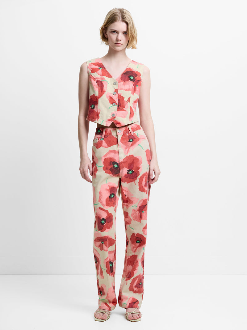 Women wearing a waistcoat and trouser denim co-ord, featuring a graphic poppy print