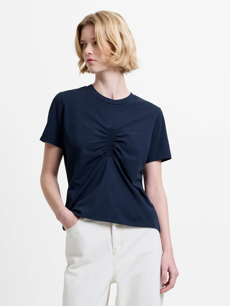 Woman wearing a short sleeve navy T-shirt with an elasticated front ruching detail