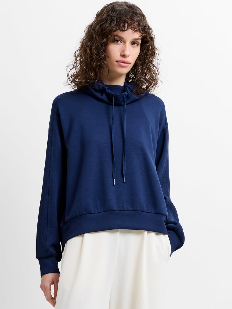 Woman wearing a navy blue drawstring hood sweatshirt
