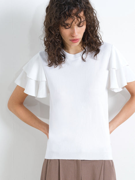 Woman wearing a white slim fit knitted top with a ribbed crew neckline and short ruffled sleeves