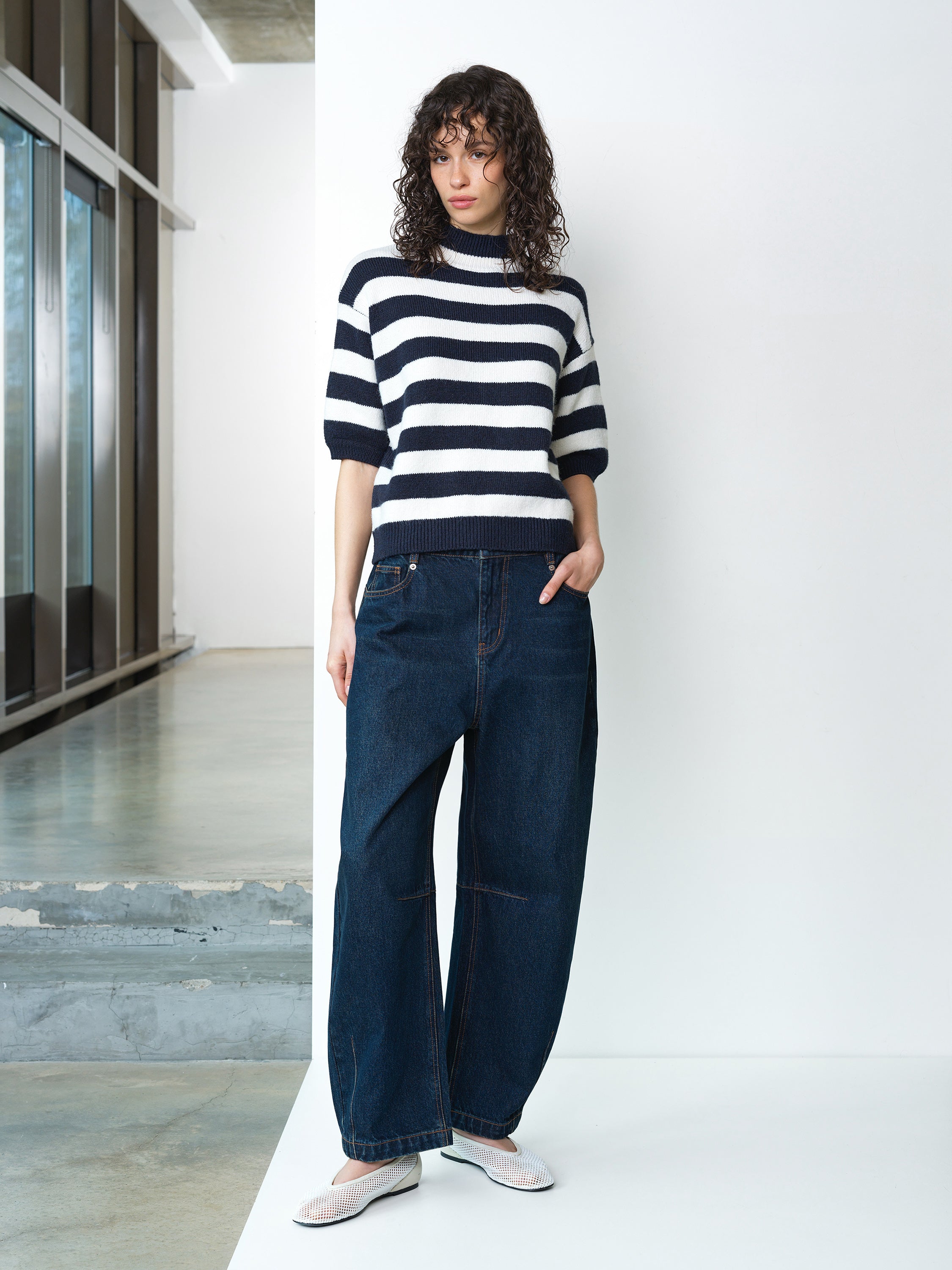 Woman wearing a navy and white striped knitted jumper, with short puff sleeves and a ribbed hem and neckline