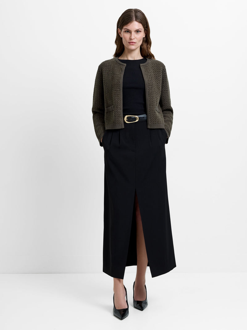 Woman wearing a khaki green cardigan with long sleeves and a crew neckline